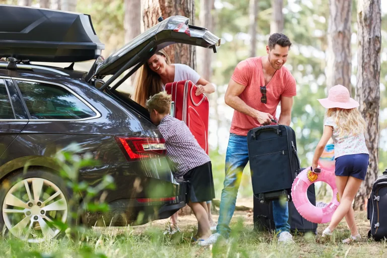 Famille chargeant ses bagages dans une voiture avant un séjour dans le Calvados